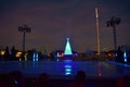 People sitting in the stadium watching ice skating rink and illuminated Christmas trees over lake in International Drive area.