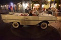 Woman parking vintage white taxi car at night at Lake Buena Vista .