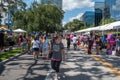 People walking on street with colorful stands at Lake Eola Park area 153.