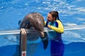 Instructor girl talking to a nice dolphin.