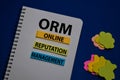 ORM - Online Reputation Management acronym write on sticky note isolated on Office Desk