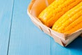 ÃÂ¡orn. Fresh yellow corn on wooden blue table closeup. Selective focus. Yellow corn in small basket on blue wooden background Royalty Free Stock Photo