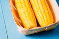 ÃÂ¡orn. Fresh yellow corn on wooden blue table closeup. Selective focus. Yellow corn in small basket on blue wooden background Royalty Free Stock Photo