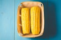 ÃÂ¡orn. Fresh yellow corn on wooden blue table closeup. Top view. Yellow corn in small basket on blue wooden background Royalty Free Stock Photo