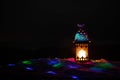 Ornamental Arabic lantern with burning candle glowing at night. Festive greeting card, invitation for Muslim holy month Ramadan