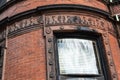 Ornamental carved stone detail around a curved window on the exterior of an old brownstone