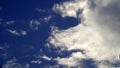 Cumulus or cluster moving clouds with blue sky background in sunny weather in a wide angle shot Royalty Free Stock Photo