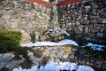 Ornamental corner of stone walls with plants and snow