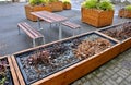 Ornamental flower pots next to the road to the square. ornamental perennial flowers grass. block shape flower pot made of wood mat Royalty Free Stock Photo