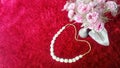 Ornamental flowers and white necklaces on a red fluffy carpet background Royalty Free Stock Photo