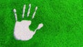 Ornamental gravel handprint on grass background