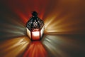 Ornamental Moroccan, Arabic lantern on the table. Burning candle at night. Colorful light rays. Greeting card for Muslim