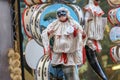 Ornamental Pulcinella Neapolitan comedy mask hanging in an outdoor marketplace setting