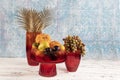 Ornamental pumpkin, fruit and grapes in a vase. Colored Glass vase fruit holder. Red glass decanter with its lid removed Royalty Free Stock Photo
