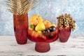 Ornamental pumpkin, fruit and grapes in a vase. Colored Glass vase fruit holder. Red glass decanter with its lid removed Royalty Free Stock Photo