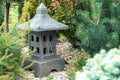 Ornamental stone lantern with among fresh green plants japanese design, outdoor garden stone statue decoration Royalty Free Stock Photo