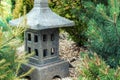 Ornamental stone lantern with among fresh green plants japanese design, outdoor garden stone statue decoration Royalty Free Stock Photo