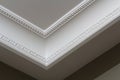 Ornamental white molding decor on ceiling of white room close-up detail. Interior renovation and construction concept. Royalty Free Stock Photo