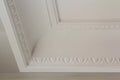 Ornamental white molding decor on ceiling of white room close-up detail. Interior renovation and construction concept. Royalty Free Stock Photo