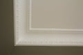 Ornamental white molding decor on ceiling of white room close-up detail. Interior renovation and construction concept. Royalty Free Stock Photo