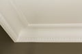 Ornamental white molding decor on ceiling of white room close-up detail. Interior renovation and construction concept. Royalty Free Stock Photo