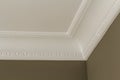 Ornamental white molding decor on ceiling of white room close-up detail. Interior renovation and construction concept.