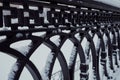 Ornamental wrought iron fence with curve parts in snow. Close up view of steel decorative fencing in winter time