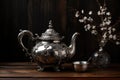 an ornate, antique silver teapot on a dark wood table