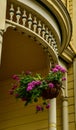 Ornate details of wood porch on Victorian house with. hanging geraniums