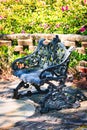 An ornate cast iron bench in a beautiful walled garden.