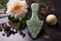 ornate ceramic gua sha tool next to blooming flower