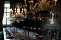 ornate chandelier above a long table with crystal glassware set