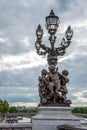 Ornate classicist Street Light with three Cherub on bridge Alexandre III, Paris Royalty Free Stock Photo