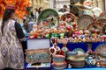 Ornate colorful oriental tableware and ceramics in market window. Seller and buyer. Silk Road