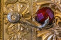 Ornate door handle with a stylized eagle foot and a red crystal in Winter Palace Hermitage museum in Saint Petersburg, Russia
