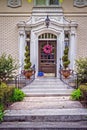 Ornate entrance to vintage luxury upscale home with landscaping and door wreath and package delivered on porch Royalty Free Stock Photo