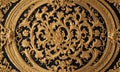 ornate gold and black circular design with intricate floral and leaf patterns, featuring central floral motif