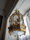 Ornate golden bird cage with clock face underneath hanging in Rosenborg Castle