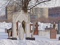 Ornate grave with statue of virgin mary in Notre Dame des Neiges Cemetery in the snow