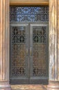 Ornate iron door framed by vertical fluted columns