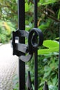 Ornate iron gate latch leading to a garden.