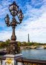Ornate lamp on the Alexander III Bridge with the Eiffel Tower in the background in Paris