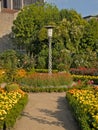 Ornate lantern in a colorful city park with flower beds in Braga
