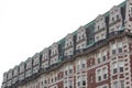 Ornate mansard roof style apartment building with brick face, green oxidized copper flashing details