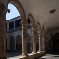 Ornate medieval arches and behind the cloister and the blue tiles panels that cover the walls of the cloister