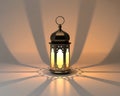 Ornate metal lantern casting intricate geometric light patterns on a neutral surface with dramatic shadows Royalty Free Stock Photo