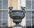 Ornate metal Urn with pair of winged cherubs outside Kingston Lacy Country House near Wimborne Minster, Dorset, UK