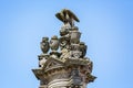 Ornate outdoor sculpture of eagle feeding young on top of large pillar outside the Cathedral in Autun, Burgundy, France