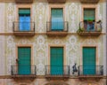 Ornate painted building facade and windows with green wooden shutters in the Gothic Quarter in Barcelona, Spain