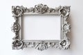 An ornate silver frame on a white wall